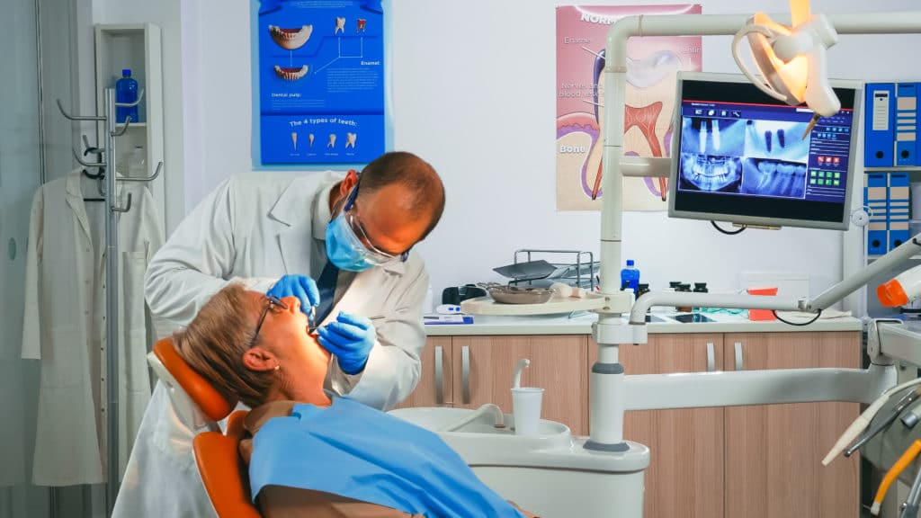 oral-surgeon-checking-with-mirror-new-dental-crown